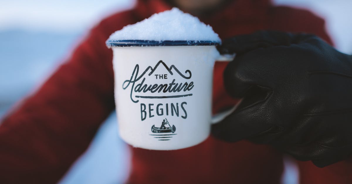 Are snow spikes for boots allowed in hand luggage? - Selective Focus Photography of Person Holding the Adventure Begins Mug