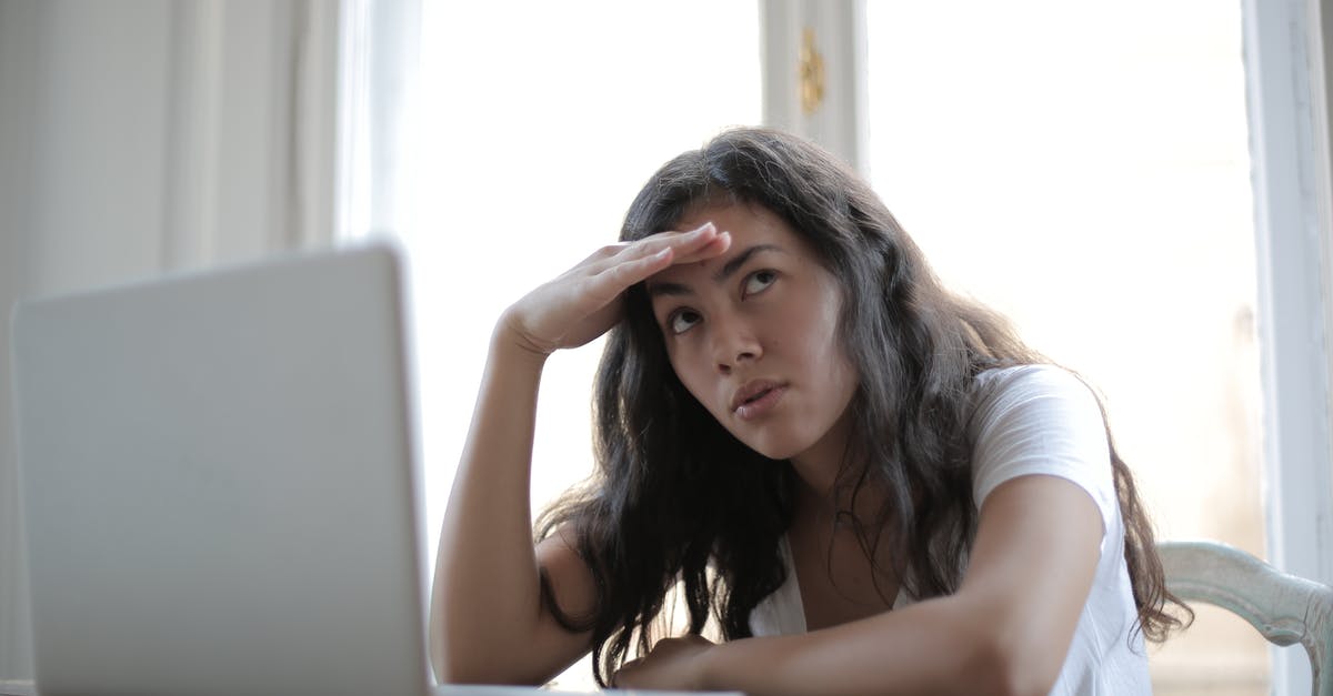 Are state boundaries a problem when using taxis in the USA? - Irritated ethnic female entrepreneur in casual wear sitting at table with netbook and touching head while waiting for internet connection during remote work