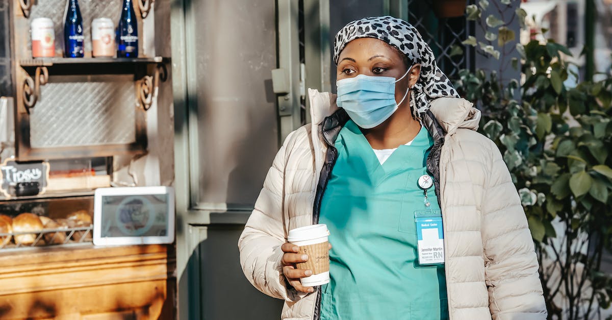 Are sunny, warm days a pipe-dream in Venice/Rome in late November? - African American lady in mask drinking coffee in street