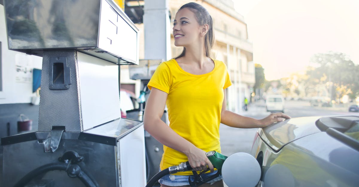 Are taxes included in fuel prices? - Woman in Yellow Shirt While Filling Up Her Car With Gasoline