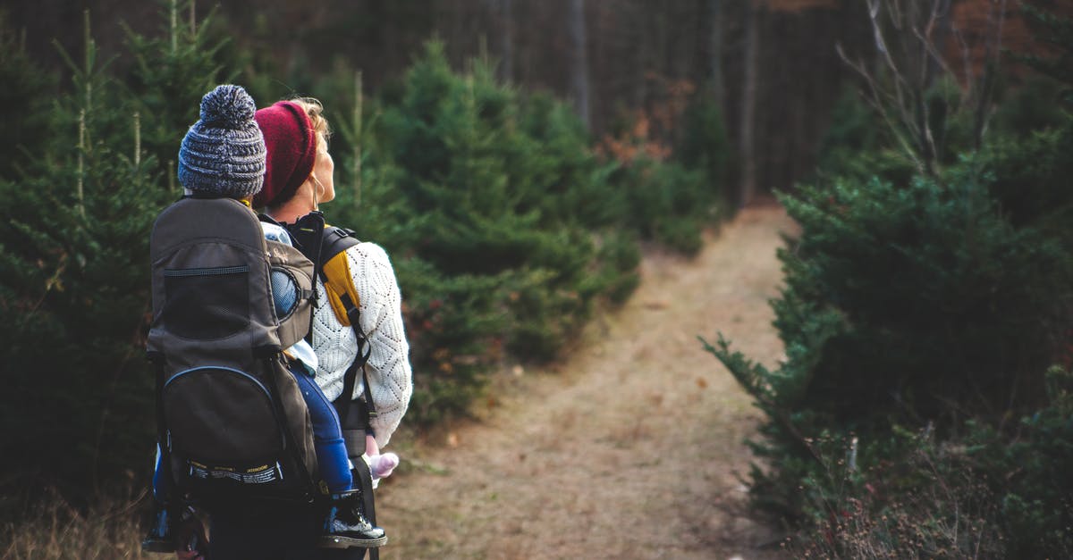 Are the child-friendly trails in the Tatras? - Shallow Focus on Blond Haired Woman in White Long Sleeve Shirt Carrying a Baby on Her Back