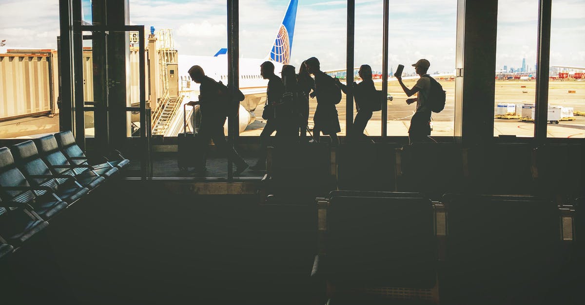 Are the windows at the airports UV protecting? - Group of People Walking Near Clear Glass Window With a View of White Airplane Parked during Daytime