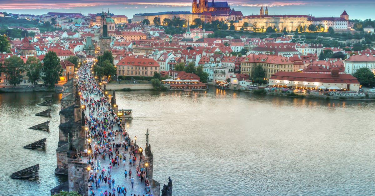 Are there any drinking-water fountains in Prague PRG airport? - People Walking on Concrete Bridge