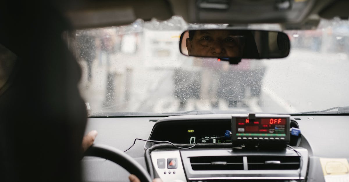 Are there any drive-in restaurants in Central Europe? - Back view of man reflecting in mirror while driving along street in city on urban background in soft daylight