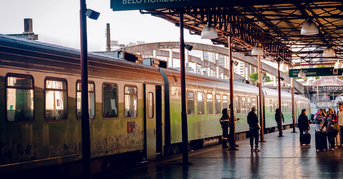 Are there any international train services in South America? - Passengers next to train on platform in daytime