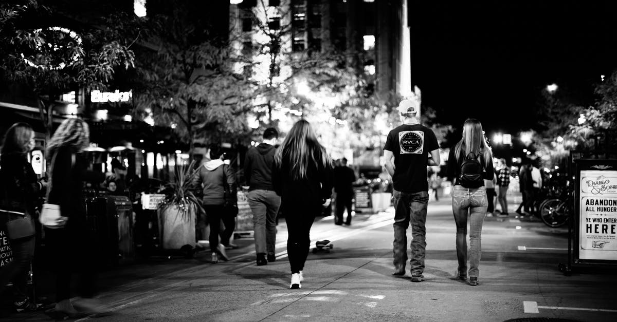 Are there any late night bars at Milano Centrale? - People walking on asphalt pavement on street