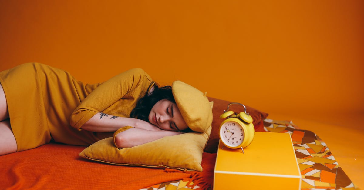 Are there any lightweight travel alarm clocks? - Photo Of Woman In Yellow Outfit Lying Down Beside An Alarm Clock