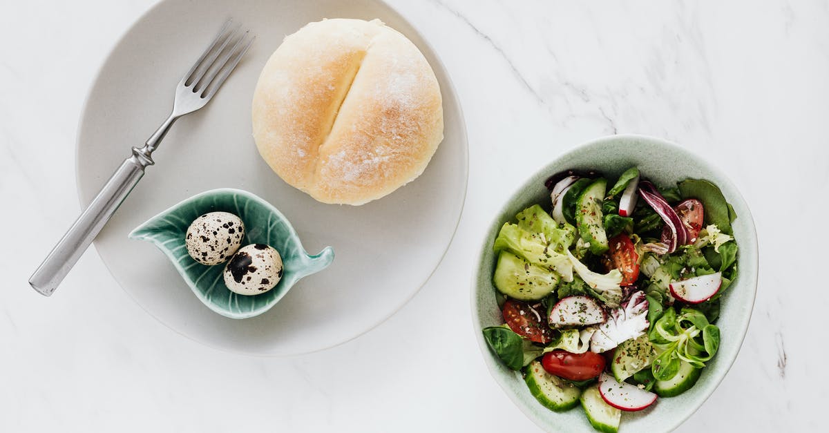 Are there any places that serve Korean food in Doi Mai or Mangalia in Romania? - From above of healthy diet salad in bowl and plate with quail eggs fork and bun placed on white marble table