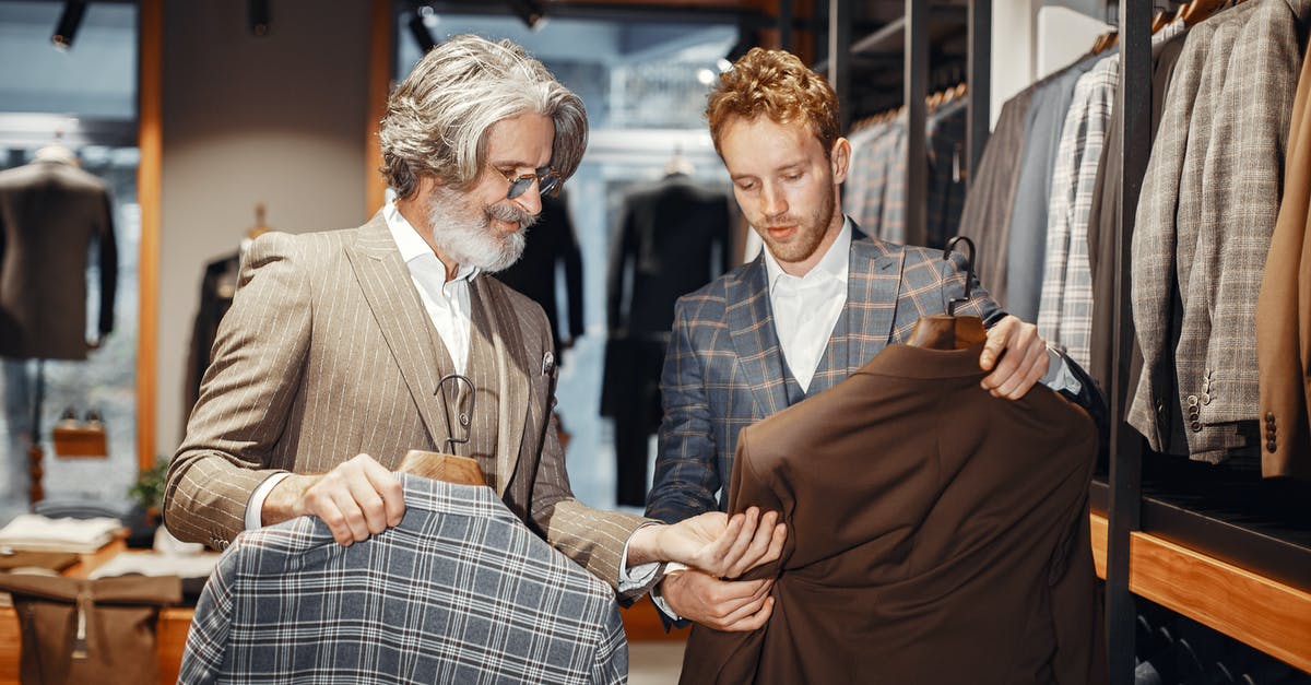 Are there any pre-check-in shops at Mumbai Airport? - Two Men in Fashion Shop with Suits and Shirts