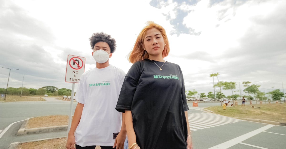 Are there any standard clothing restrictions when visiting mosques? - Man in Black Crew Neck T-shirt Standing Beside Woman in White T-shirt