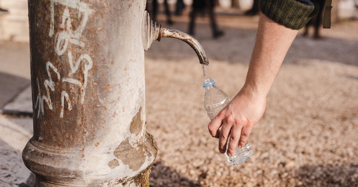 Are there drinking water fountains airside at London City Airport? - Crop person filling bottle with water from drinking fountain