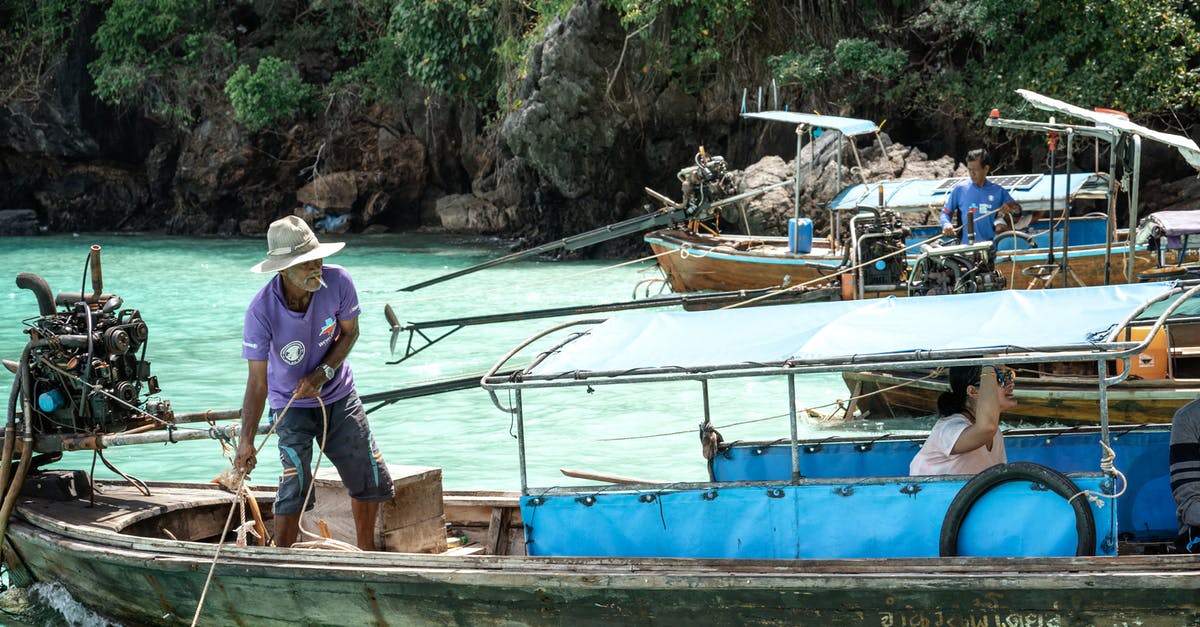 Are there local boat operators that go to Cies Islands? - Unrecognizable man fishing on boat floating on river