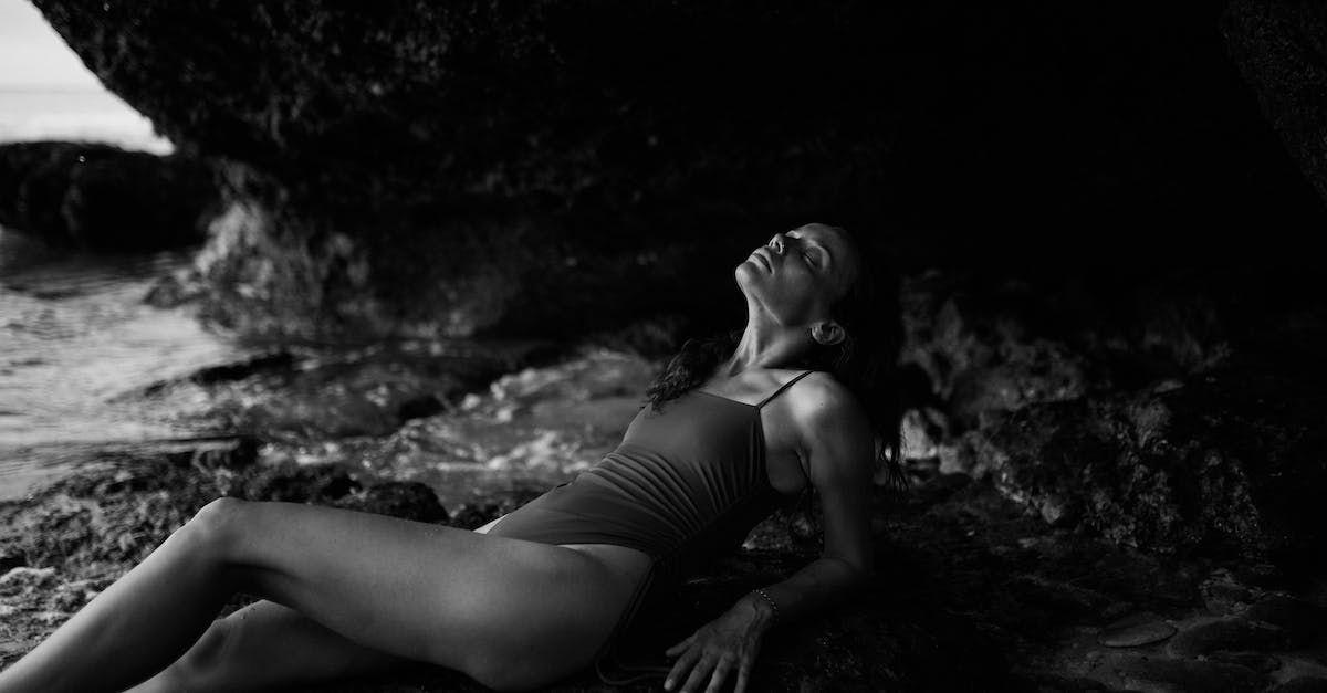 Are there organized multiday cave trips in Europe? - Sensual young woman lying on stone in cave near sea