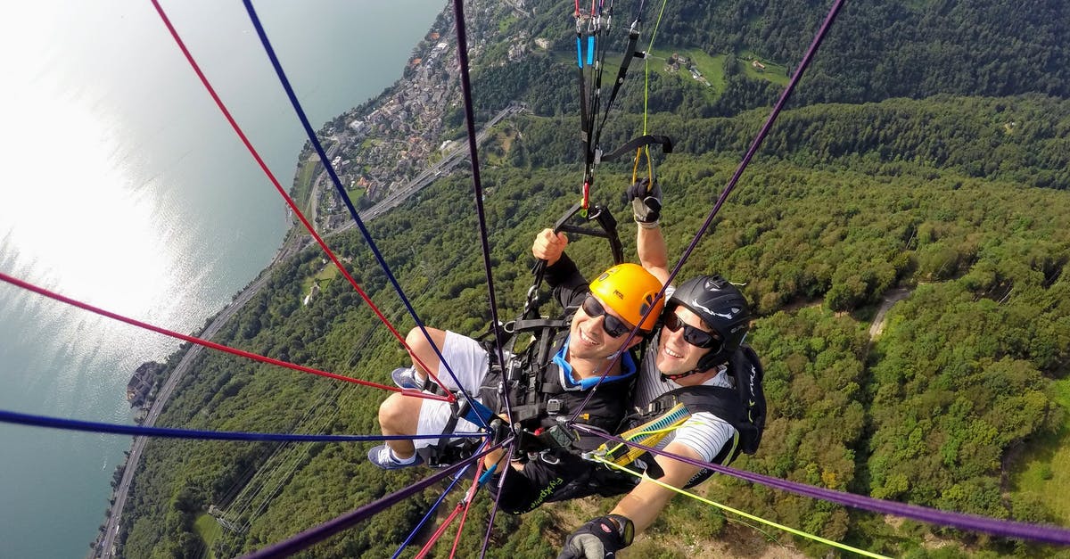 Are there paraglide/paramotor operators around Lake Toba? - People Riding Cable Cars over Green Mountain