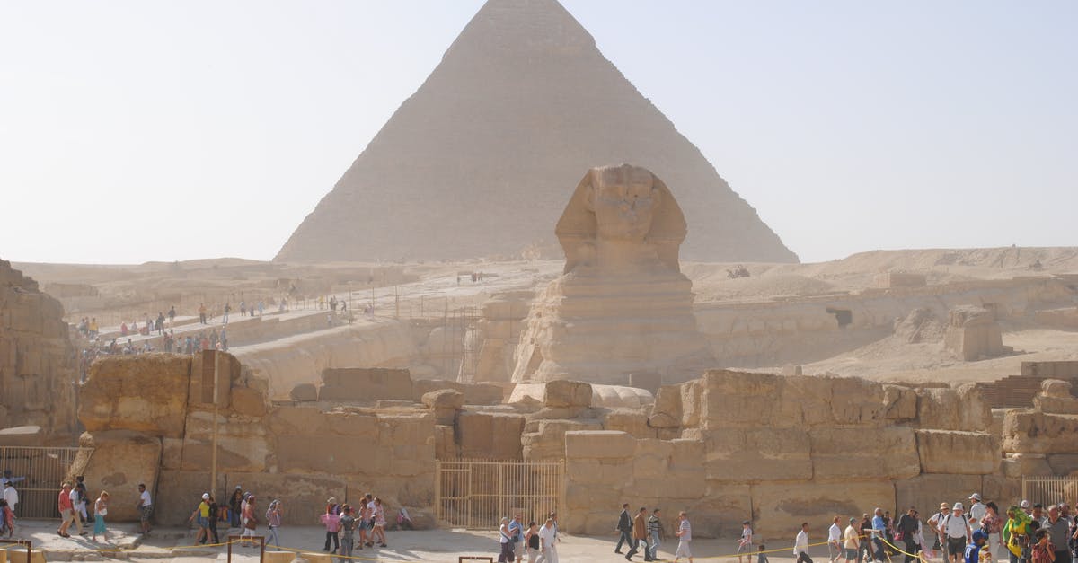 Are there "Doctor Who" themed tourist attractions in the UK? - Unrecognizable distant travelers walking on old path near ancient Sphinx statue and Great Pyramid of Giza located in Egypt on sunny day