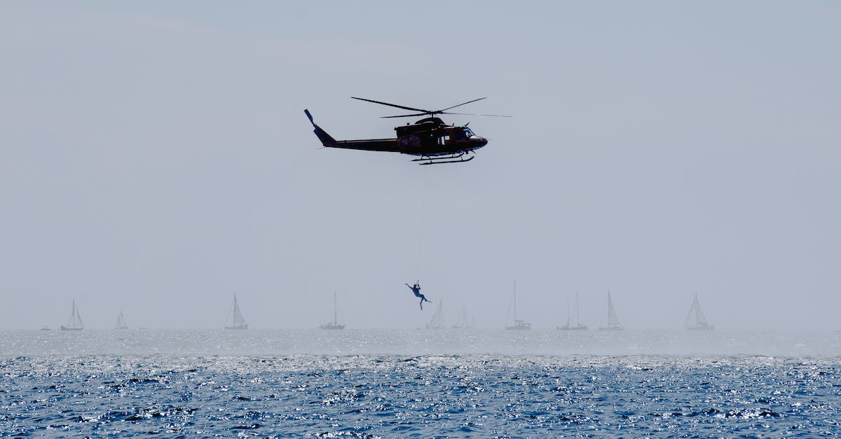Are there scheduled flight connections operated with a helicopter? - Copter landing anonymous military parachutist over wavy ocean with sailboats during professional practice in daytime