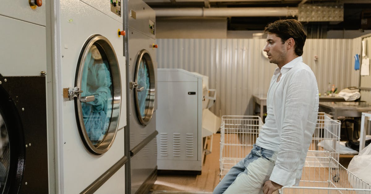 Are there self-service laundries in Arendal? - A Man Waiting For His Clothes in a Self-Service Laundry