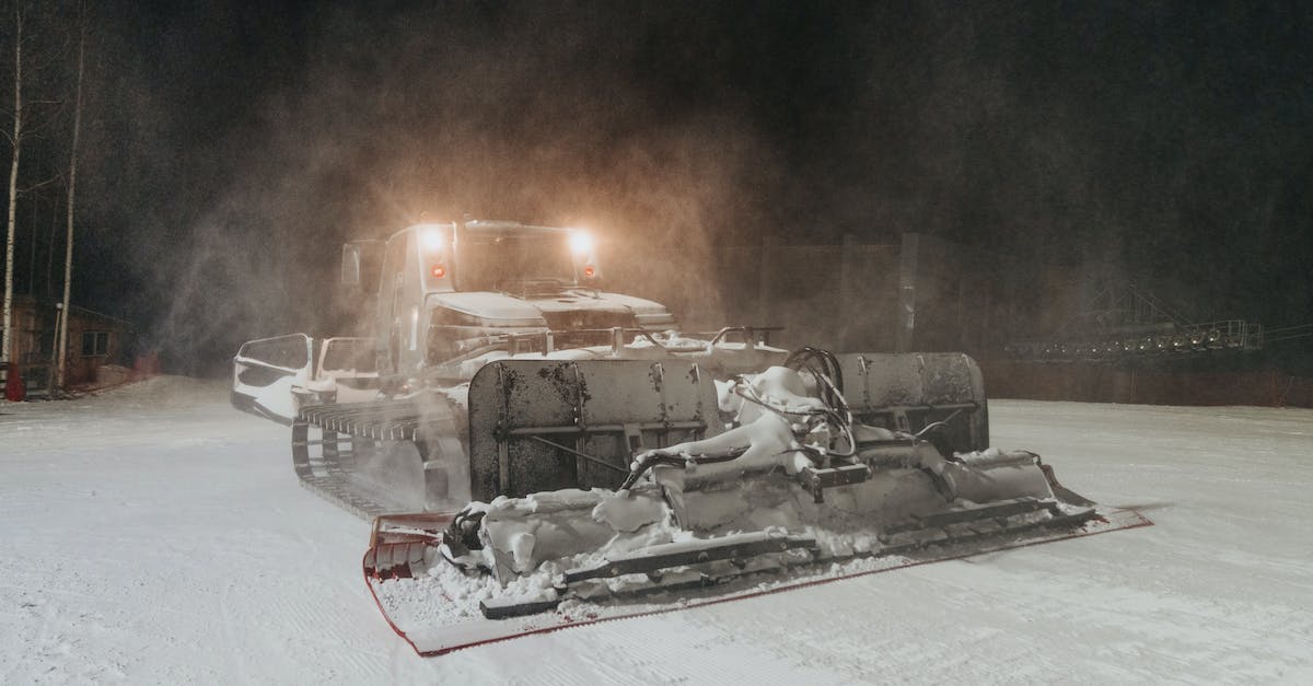Are there ski resorts that you can drive to in an evening from Atlanta, GA? - Modern massive snowcat with headlights driving and preparing slope for skiing in evening time