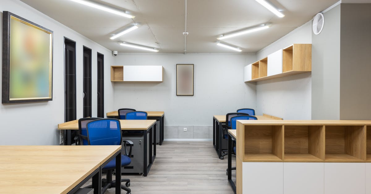 Are there ski/snowboard storage facilities in Whistler? - Interior of contemporary workspace with office chairs at tables and wooden shelves under ceiling with geometric lamps