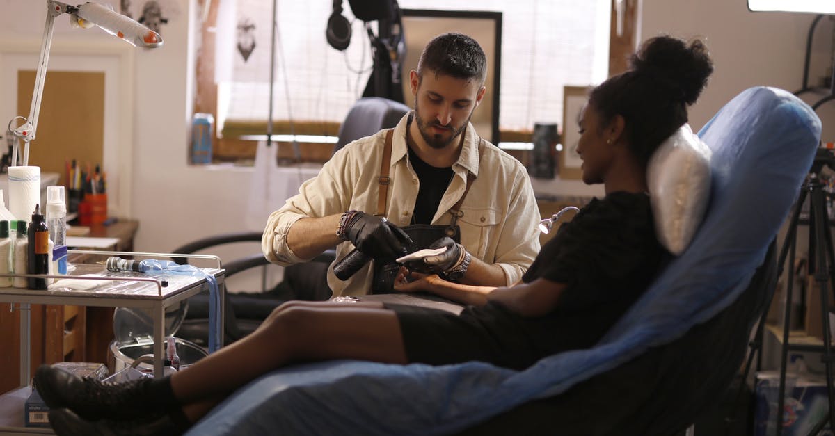 Are there sterile transfer areas in Juan Santamaria airport? - Serious male tattooist preparing client for tattoo in modern salon