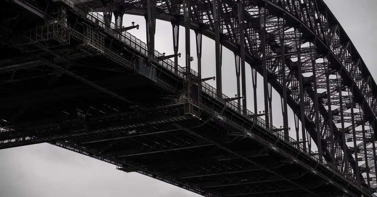 Are there still any "cheap" options for flying from Australia to Mexico without going through the US? - Black and white from below famous Sydney Harbor Bridge with arch trusses beneath gloomy sky