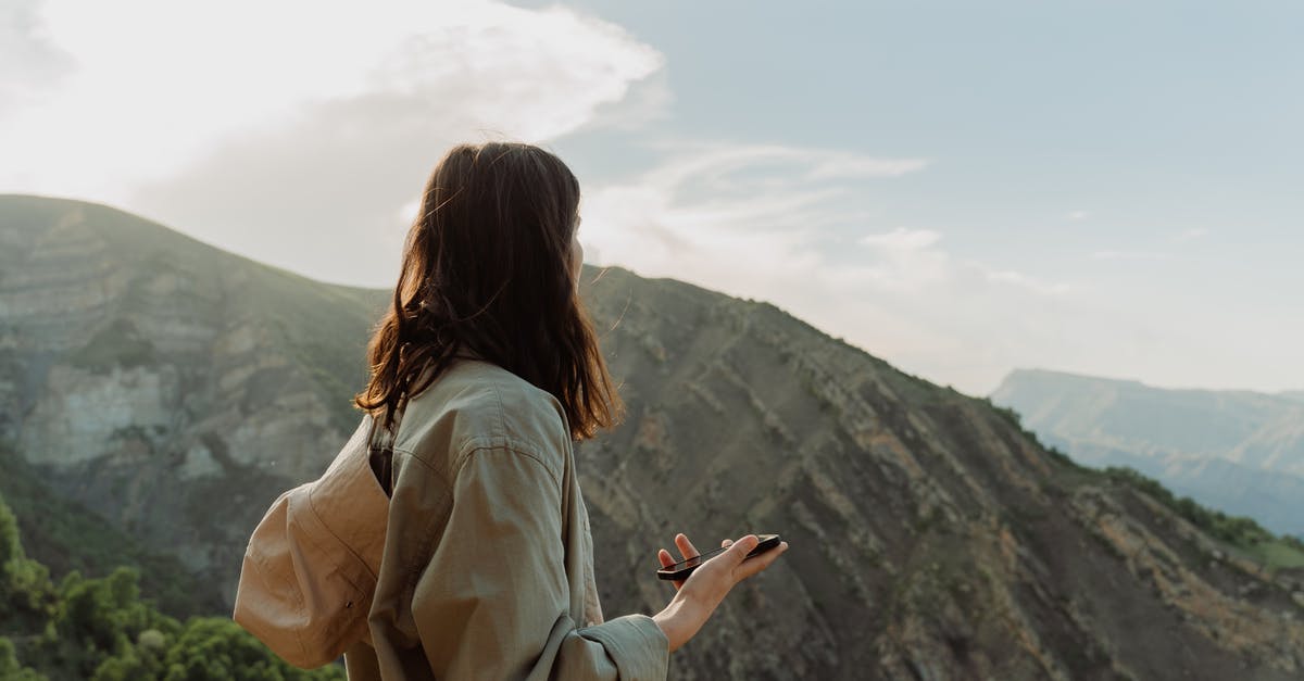 Are there tourist traps in the Sanya tourist area? - Woman in Jacket Standing on Mountain Area