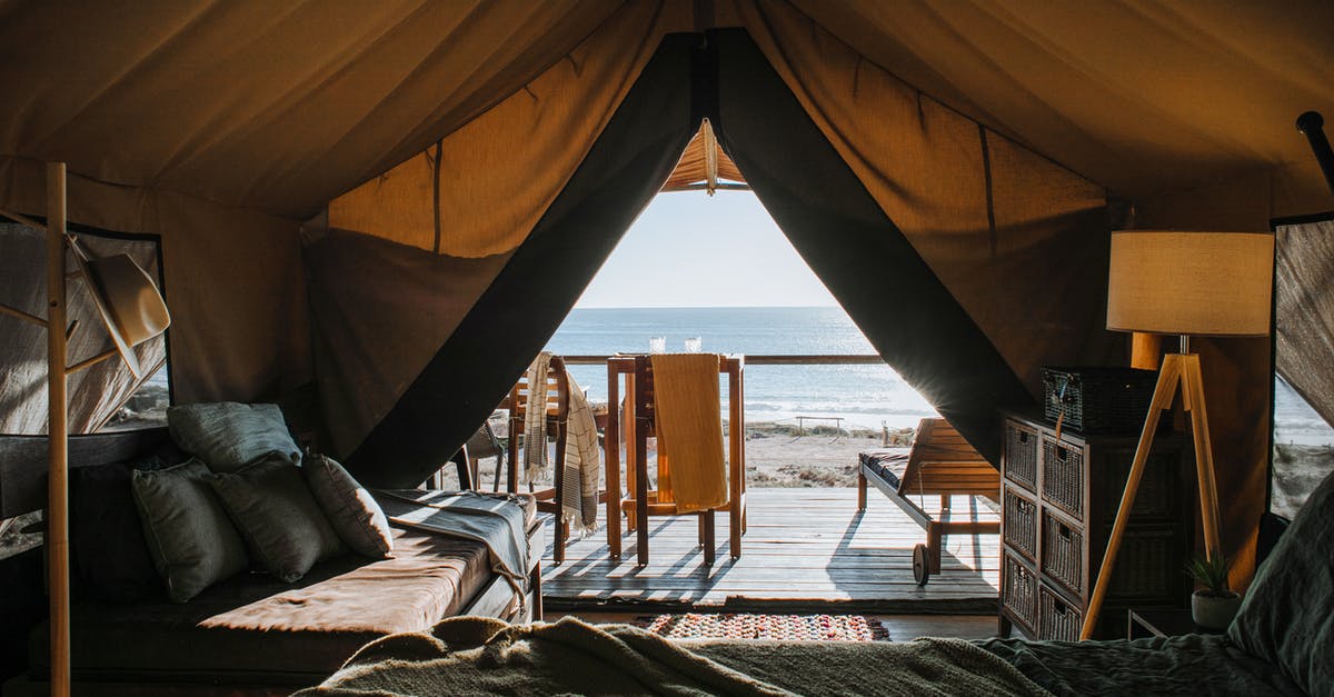 Are they entitled to a hotel accommodation during transit? - Cozy tent with bed and terrace on beach