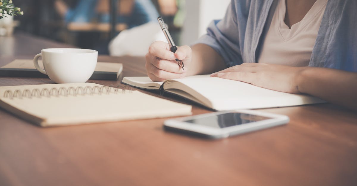 Are visa application forms for Morocco available online? - Woman Writing on a Notebook Beside Teacup and Tablet Computer