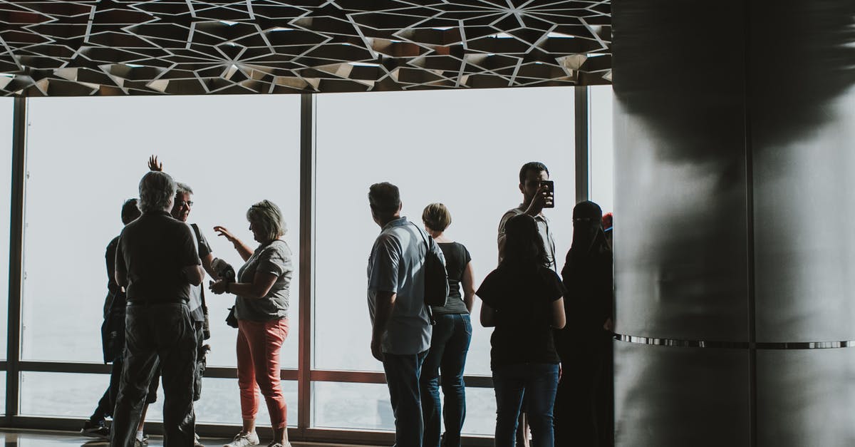 Are visitors allowed in Dubai Airport? - Group of People Standing on White Floor