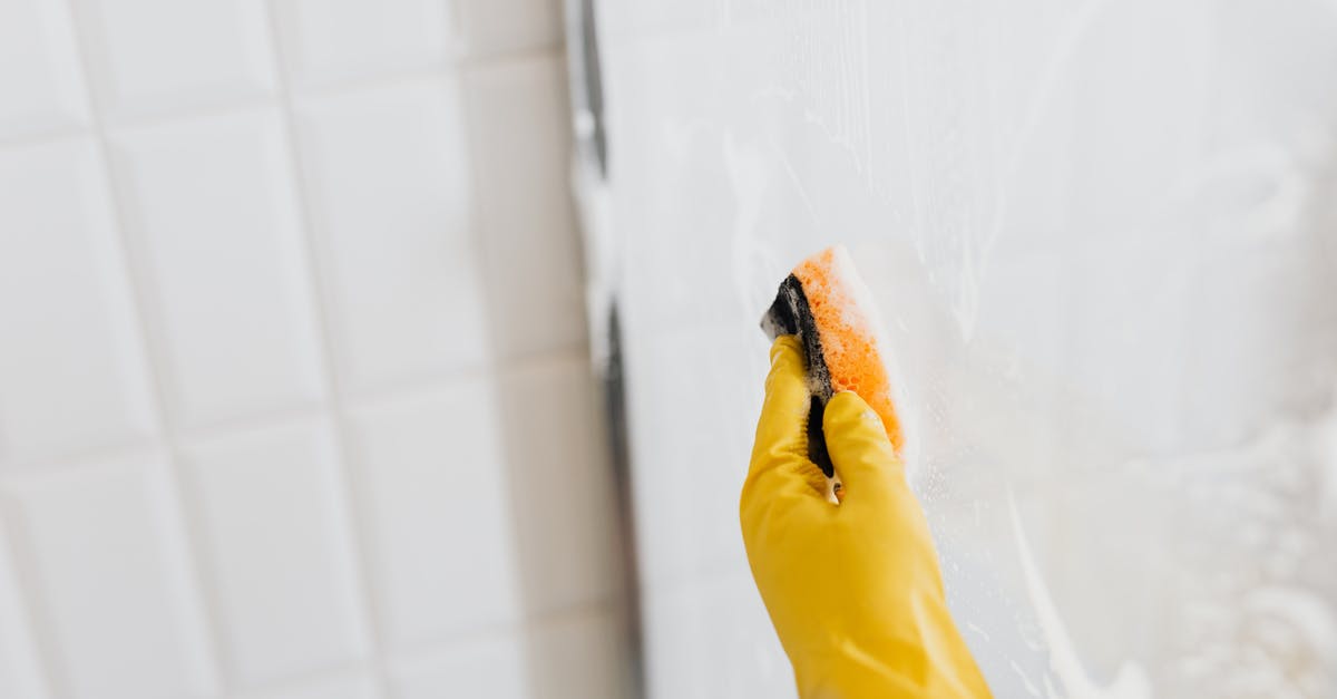 Are wet wipes subject to the TSA's 3-1-1 Liquids Rule? - From above of crop anonymous person in yellow rubber protective glove washing shower cabin glass with sponge and detergent