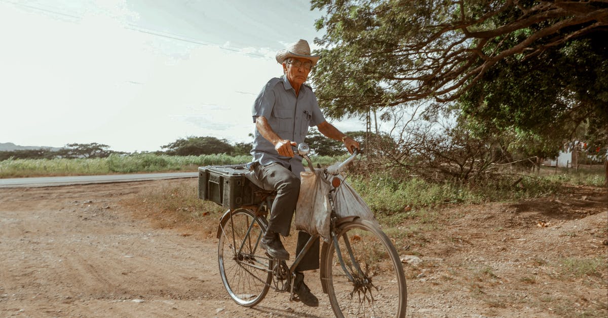 Are ziploc bags banned in Rwanda for air travelers? - Elderly male in hat riding bike on dry roadway and looking at camera under cloudy sky