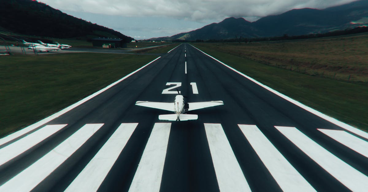 Arrival at airport for flights into USA - White and Black Road Sign on Green Grass Field