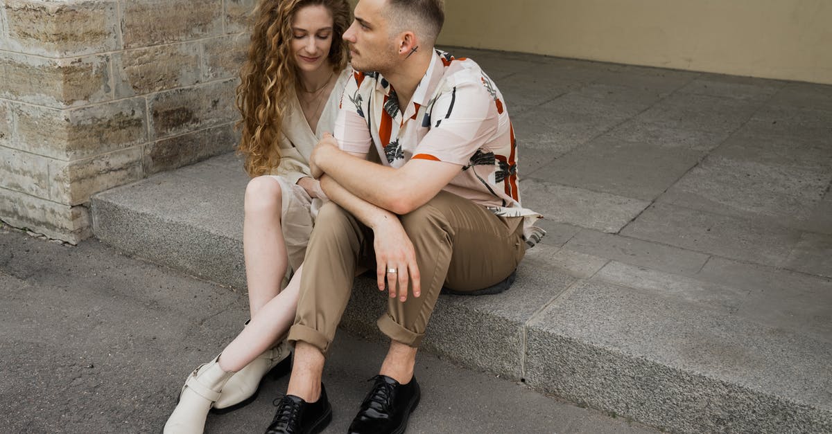 Arriving Before Visa Start Date - Man and Woman Sitting on Concrete Bench