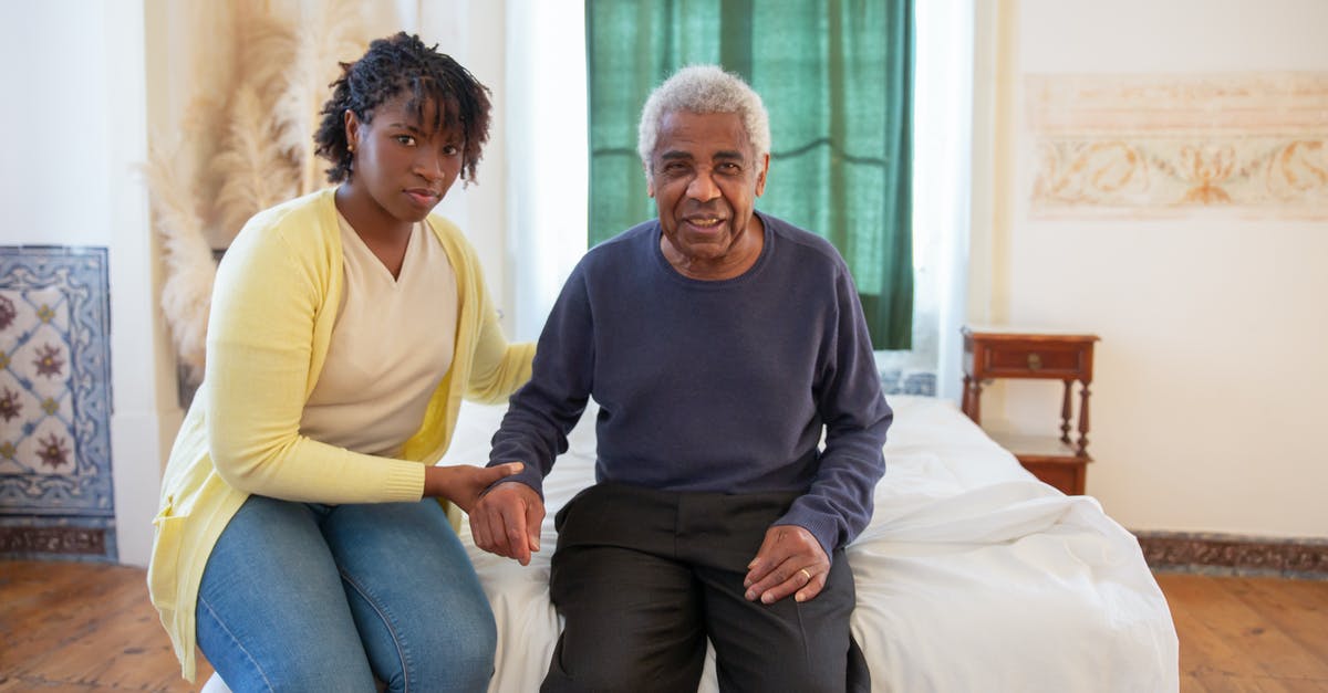 Assistance for an elderly non-revenue air passenger - Woman and Elderly Man Sitting on Bed