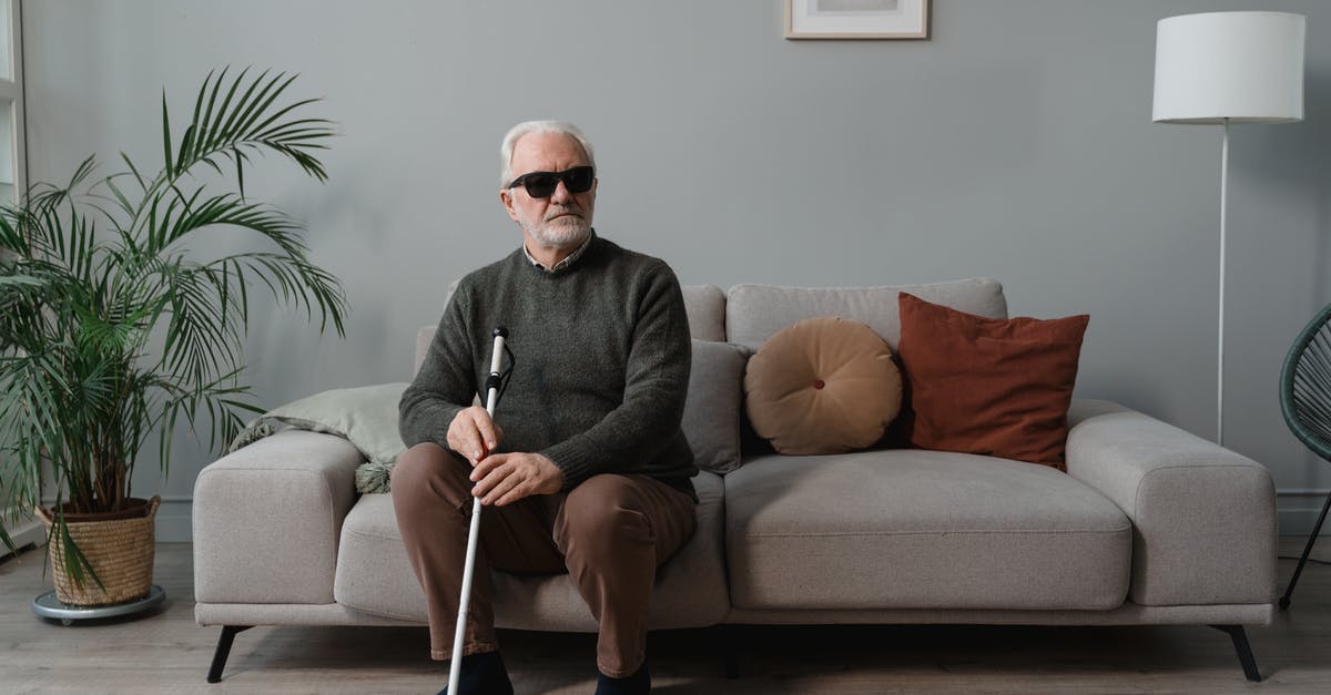 Assistance for an elderly non-revenue air passenger - A Blind Man Wearing Sunglasses while Holding His White Cane