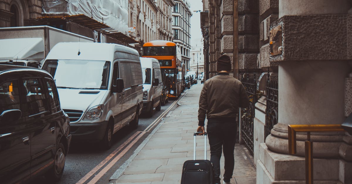 Assistance with luggage at London Heathrow - Man in Brown Jacket Holding Black Travel Luggage