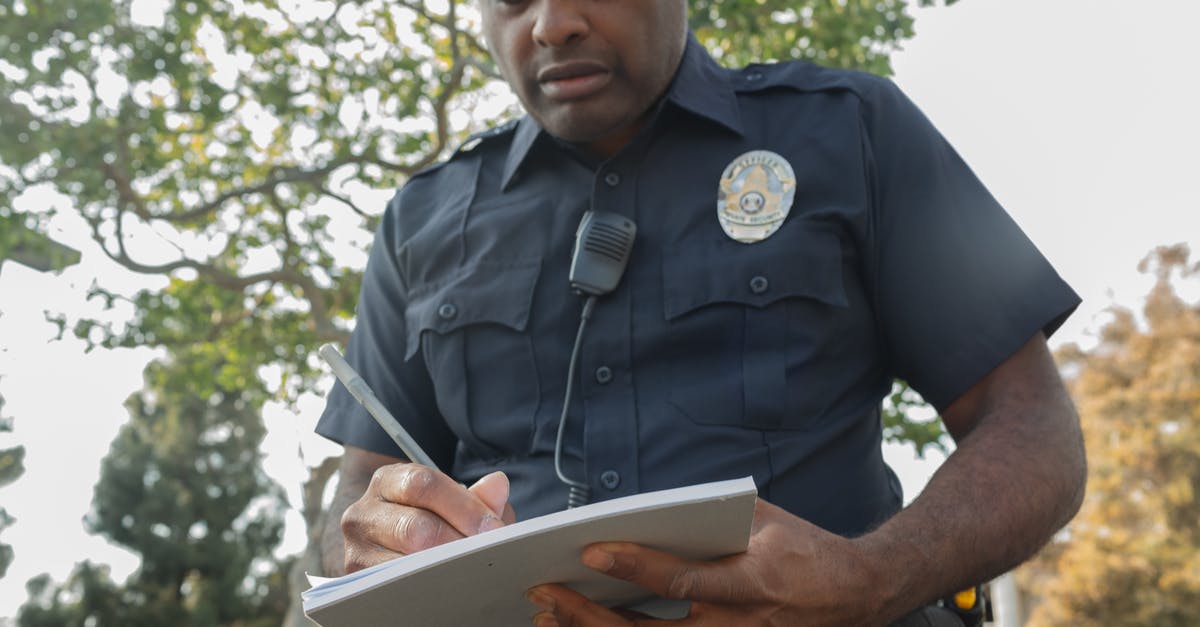 Australia ETA with prior speeding ticket - Man in Black Police Uniform Writing on White Book