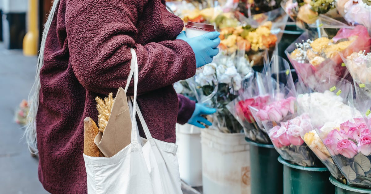 Australia: How to know price of goods in groceries - Woman with paper cup of coffee buying flowers on street