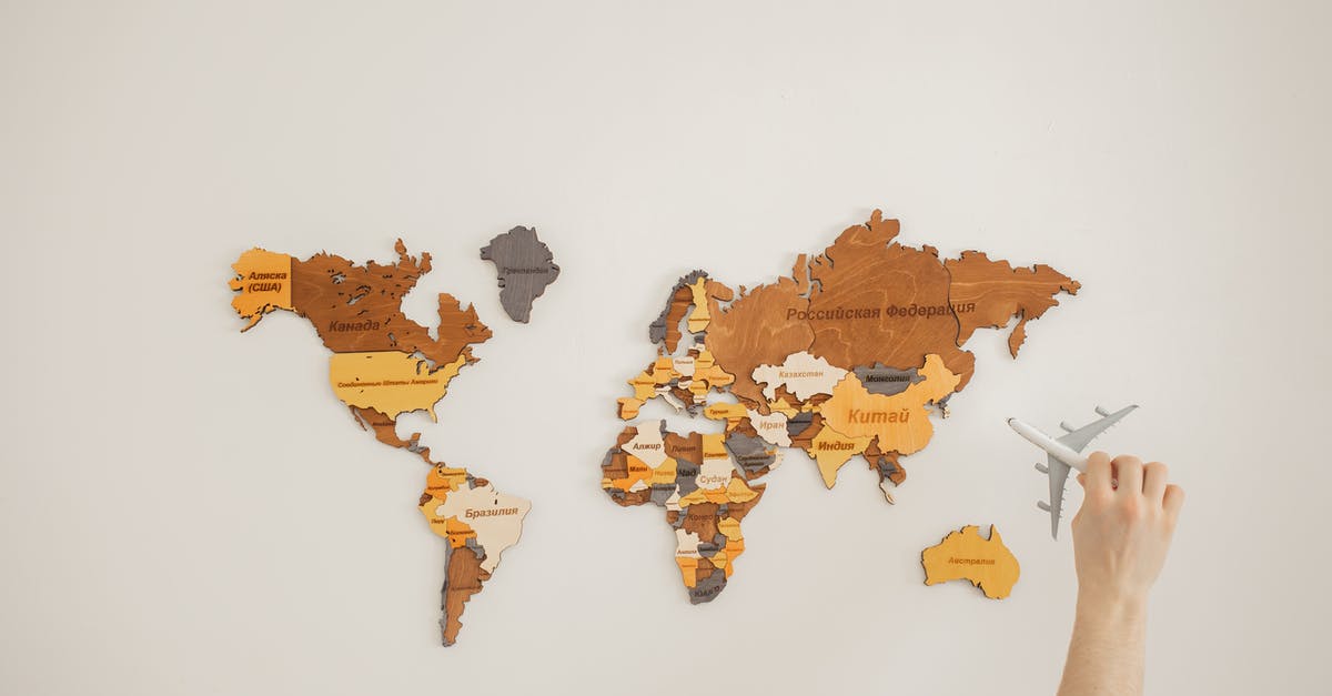 Australia visitor visa: are the additional attachments after payment necessary? - Crop anonymous traveler with toy aircraft over decorative wooden world map with country names on white background in light room