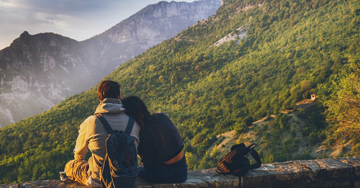 Australian and British defacto couple travelling in the EU - Couples Sitting in While Facing Mountain