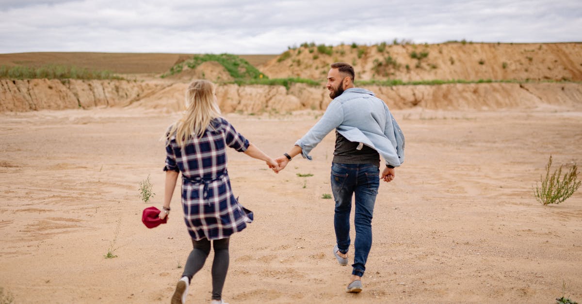 Australian Visa date - confused arrival date - Couple Holding Hands and Walking on Beach