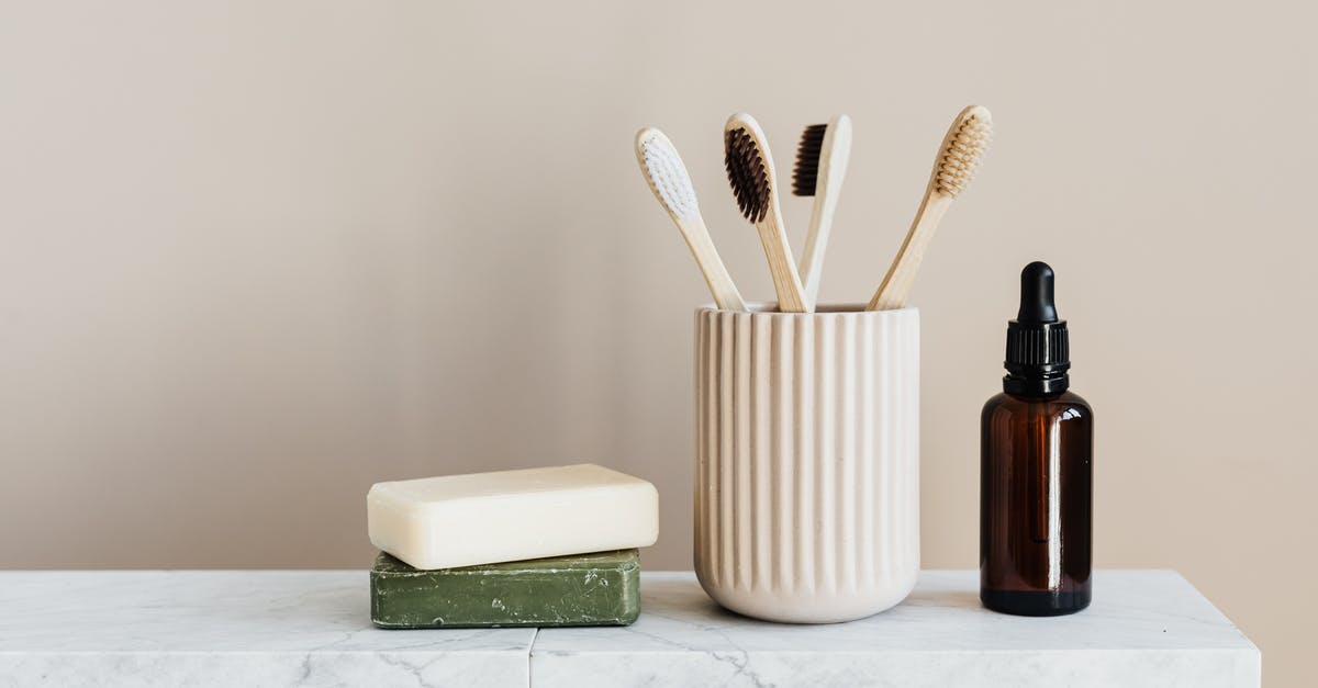 Australian visa requirement for a USA green card holder - Collection of organic soaps and bamboo toothbrushes in ceramic minimalism style holder placed near renewable glass bottle with essential oil on white marble tabletop against beige wall