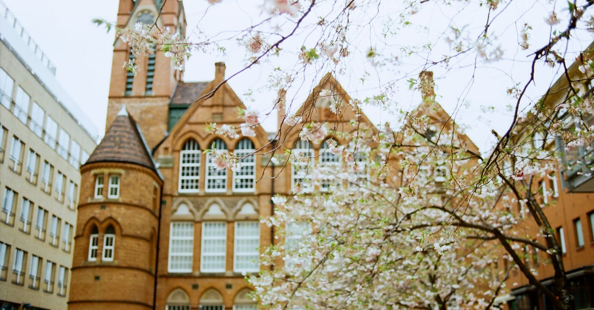 Authenticating a denial by UK embassy - Exterior of historic building with clock on spire in Birmingham on clear spring day