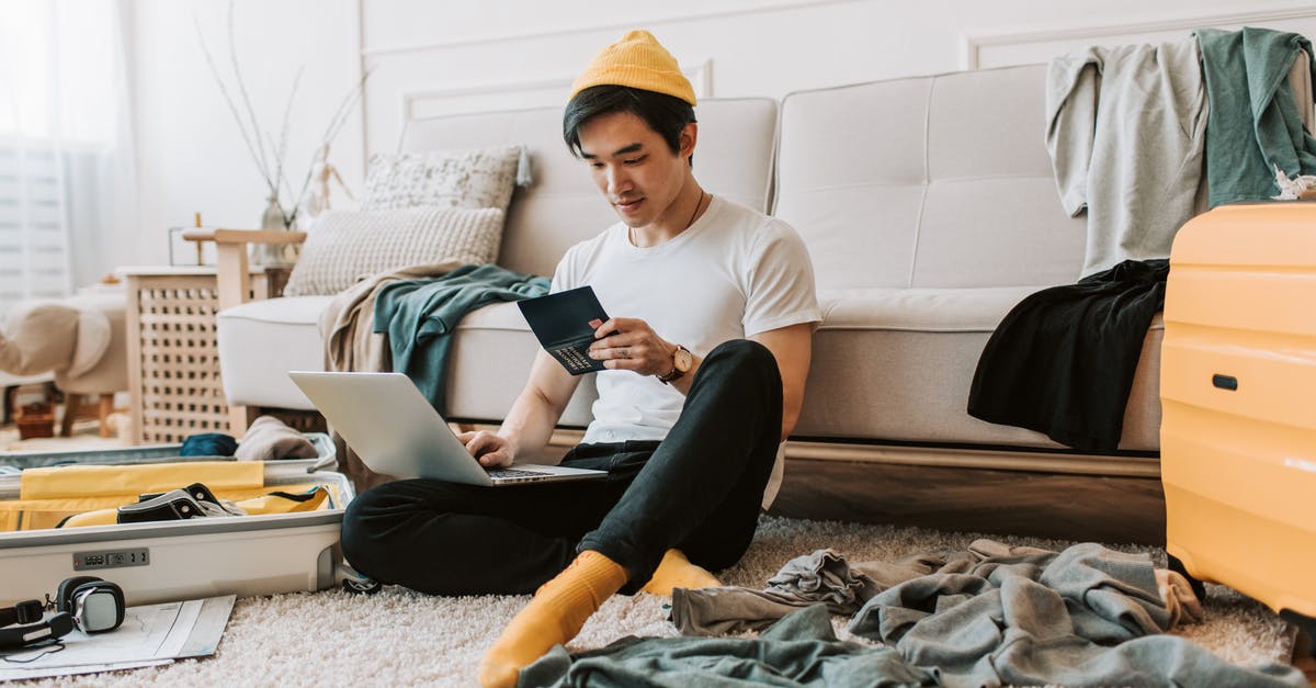 Authorizing someone else for in-person passport renewal - A Man Using His Laptop in a Messy Living Room