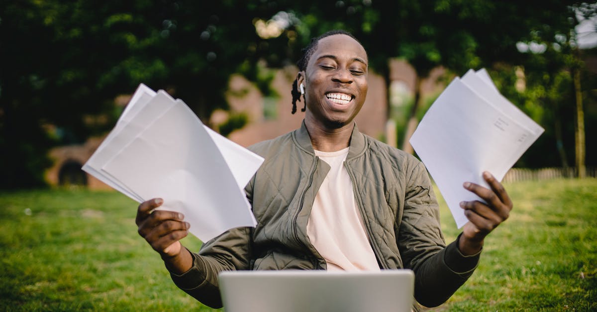 Automated passport kiosks, deferral with ER using Green Card - Student with documents and laptop happy about getting into university