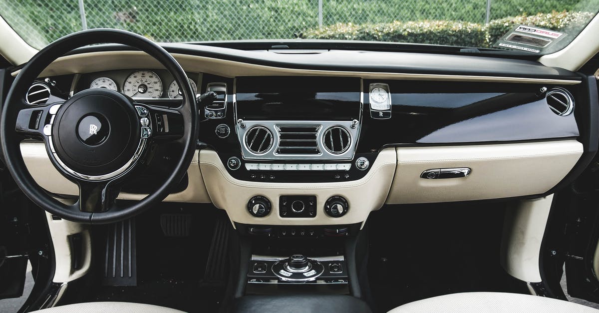 Available seat choices on British Airways flights - High angle interior of luxury car with leather seats and black wooden dashboard parked on street near green plants on sunny day