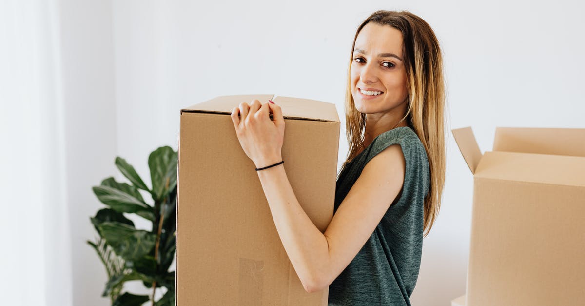 Avoiding important carry-on luggage being taken away - Cheerful woman carrying packed carton box