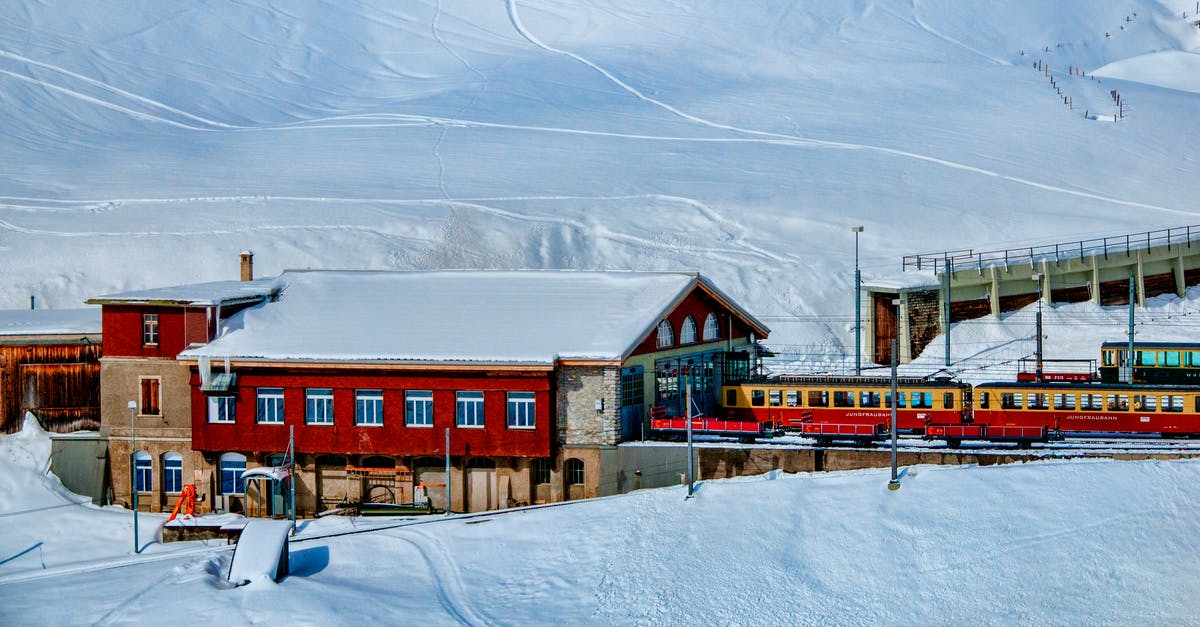 Avoiding tilting trains in Switzerland - Yellow and Red Train Beside Snowy Mountain