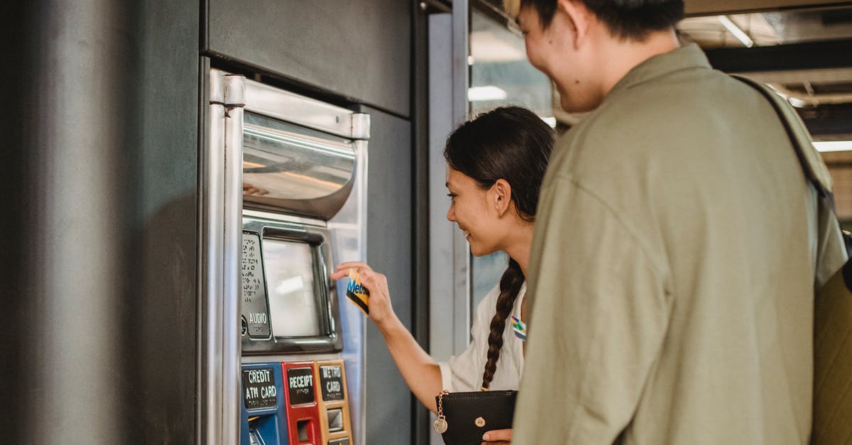 Award travel by combining money payment and miles with United Airlines - Content couple using ticket machine in underground