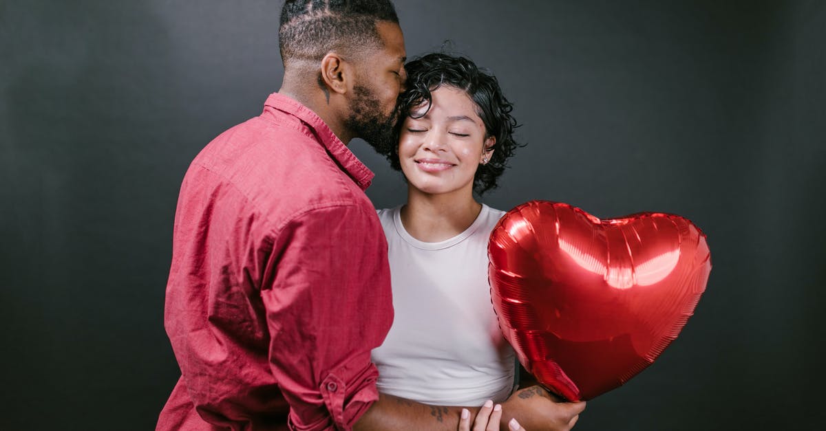 B2 Visa for my Employee/Partner - Man Kissing His Woman While Holding a Red Heart Shaped Balloon